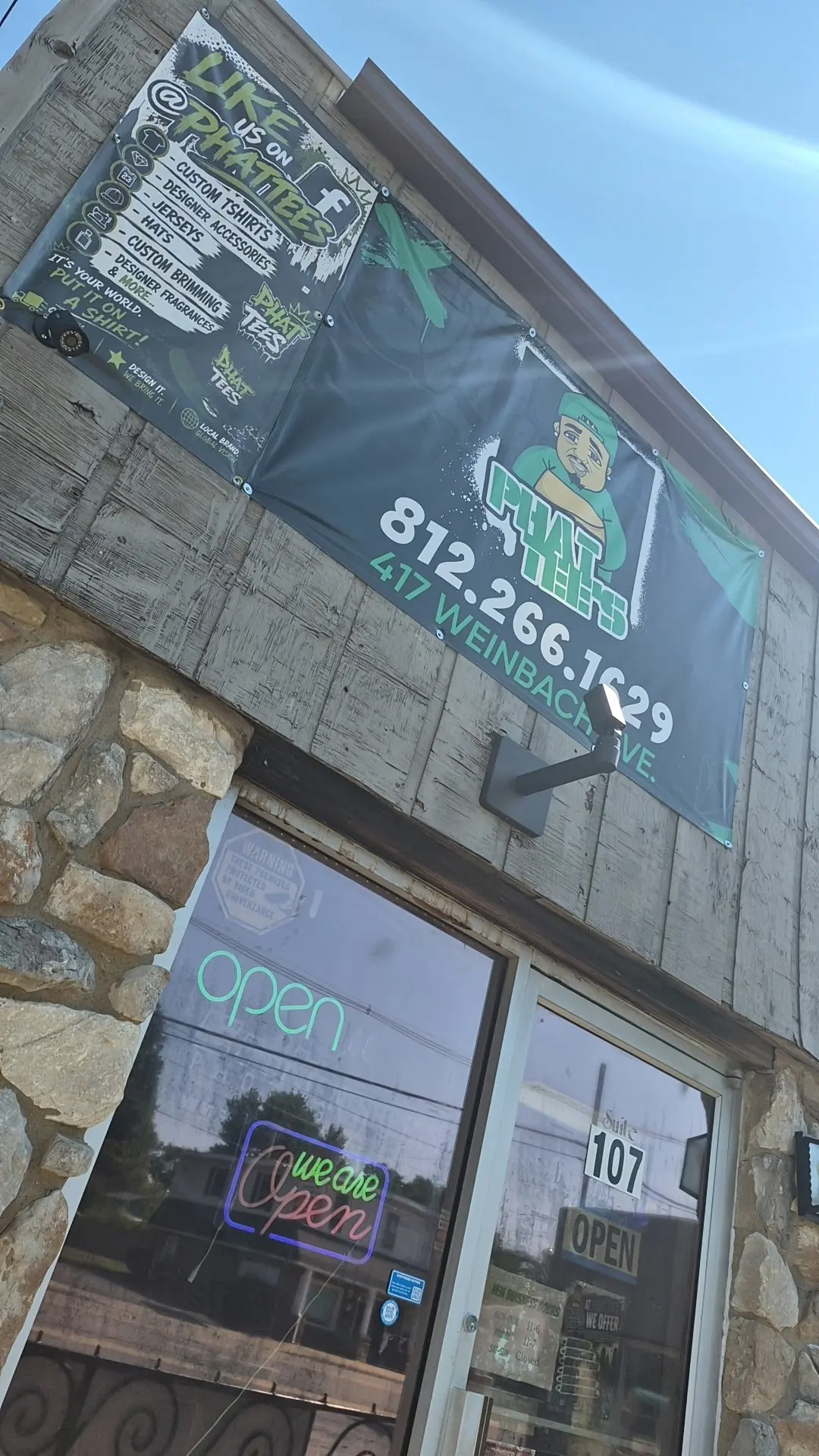 Exterior of Phat Tees at 417 North Weinbach Avenue with open signs