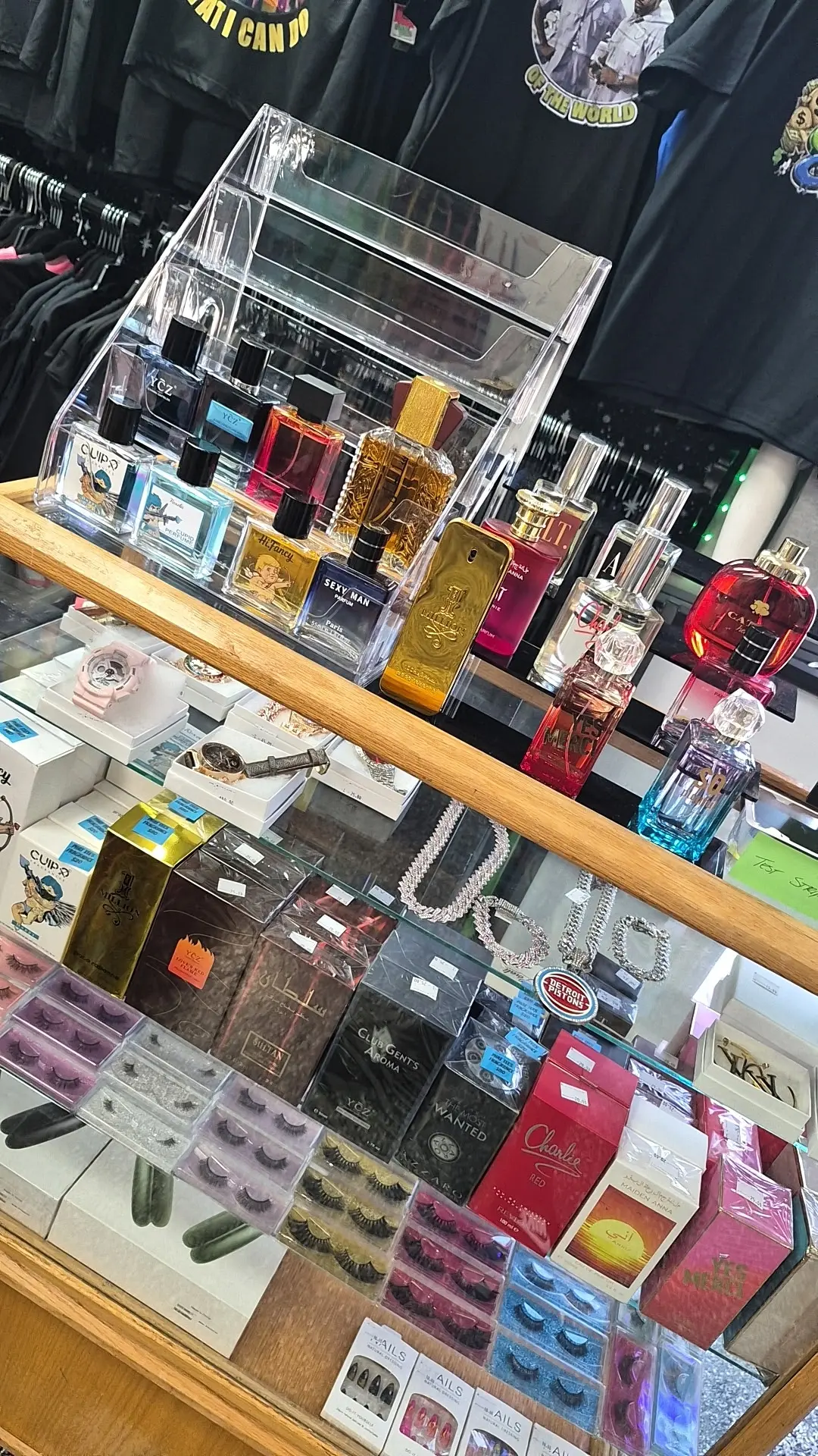 Fragrance bottles displayed on a glass case inside Phat Tees