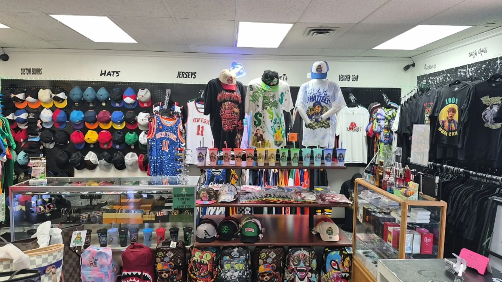 Phat Tees hat wall, mannequins, tumblers, and store merchandise