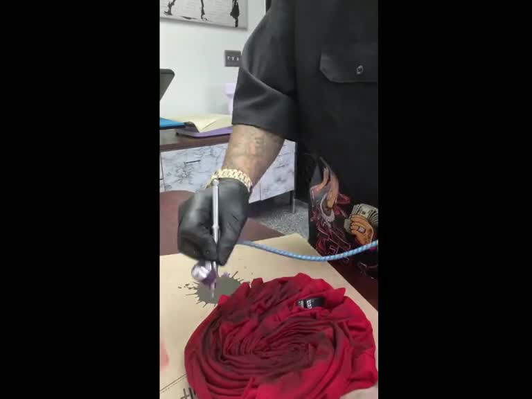Tez making custom garments and pressing a hat